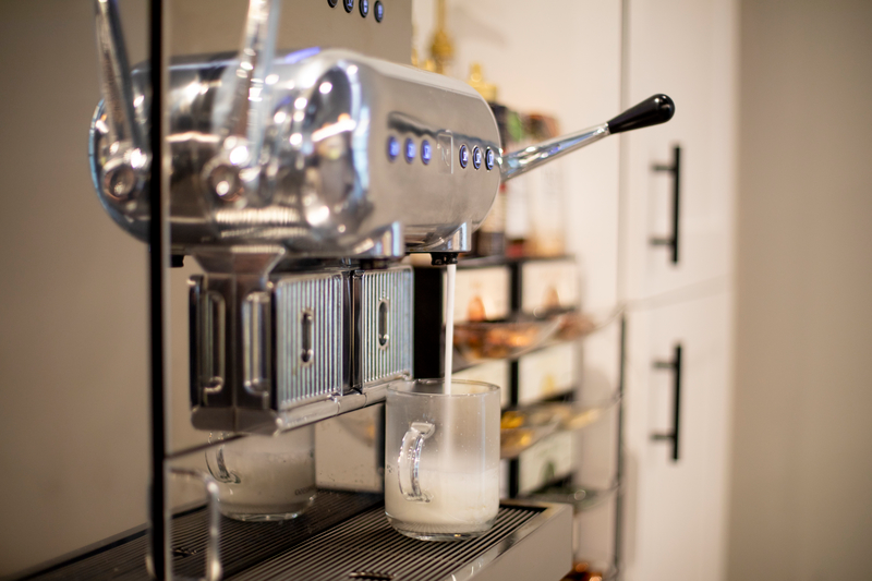 一台高端的Nespresso咖啡机将热牛奶倒入杯中的饮料中